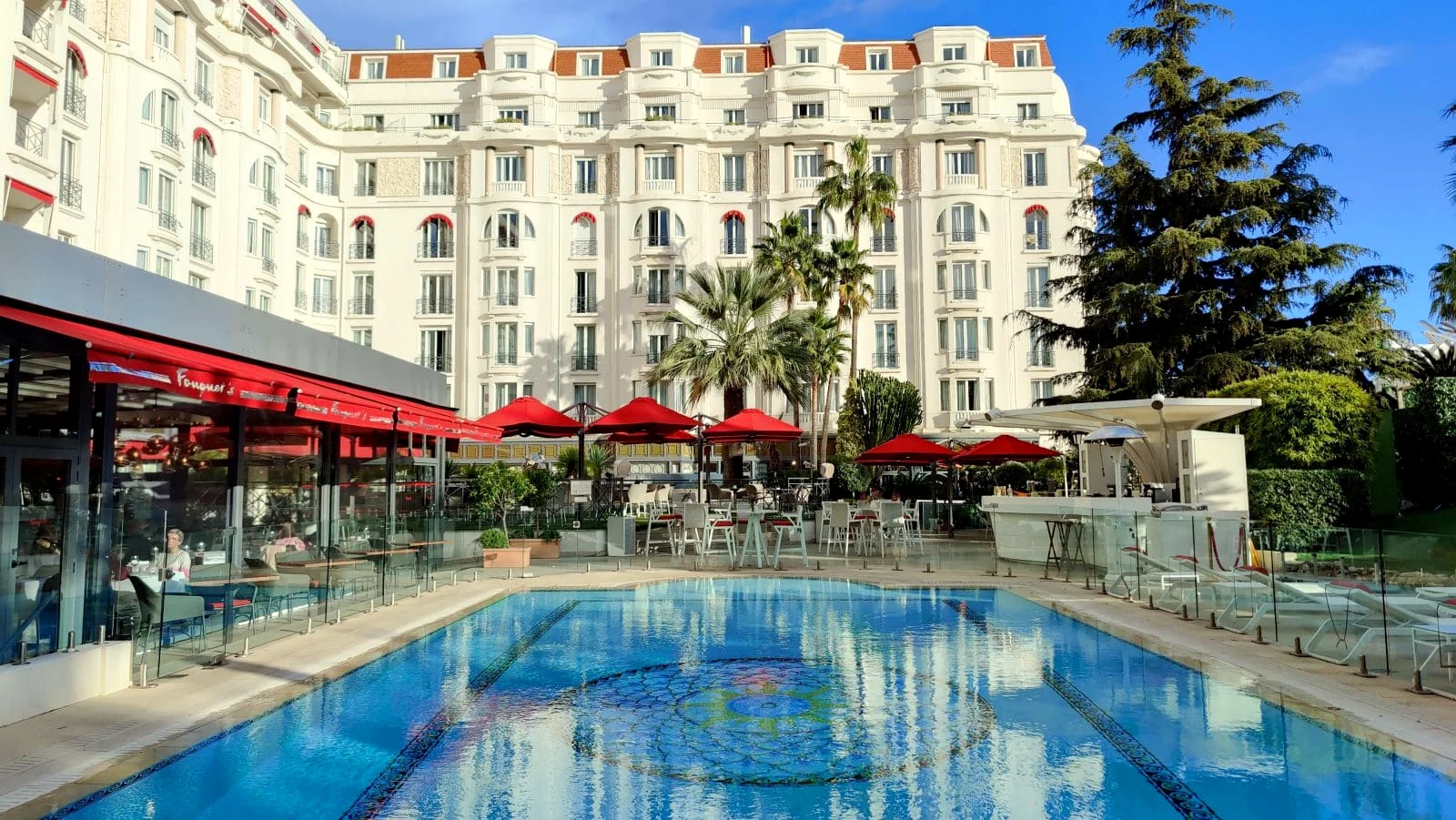 Piscine turquoise et façade Belle Époque d'un palace de La Croisette, Cannes